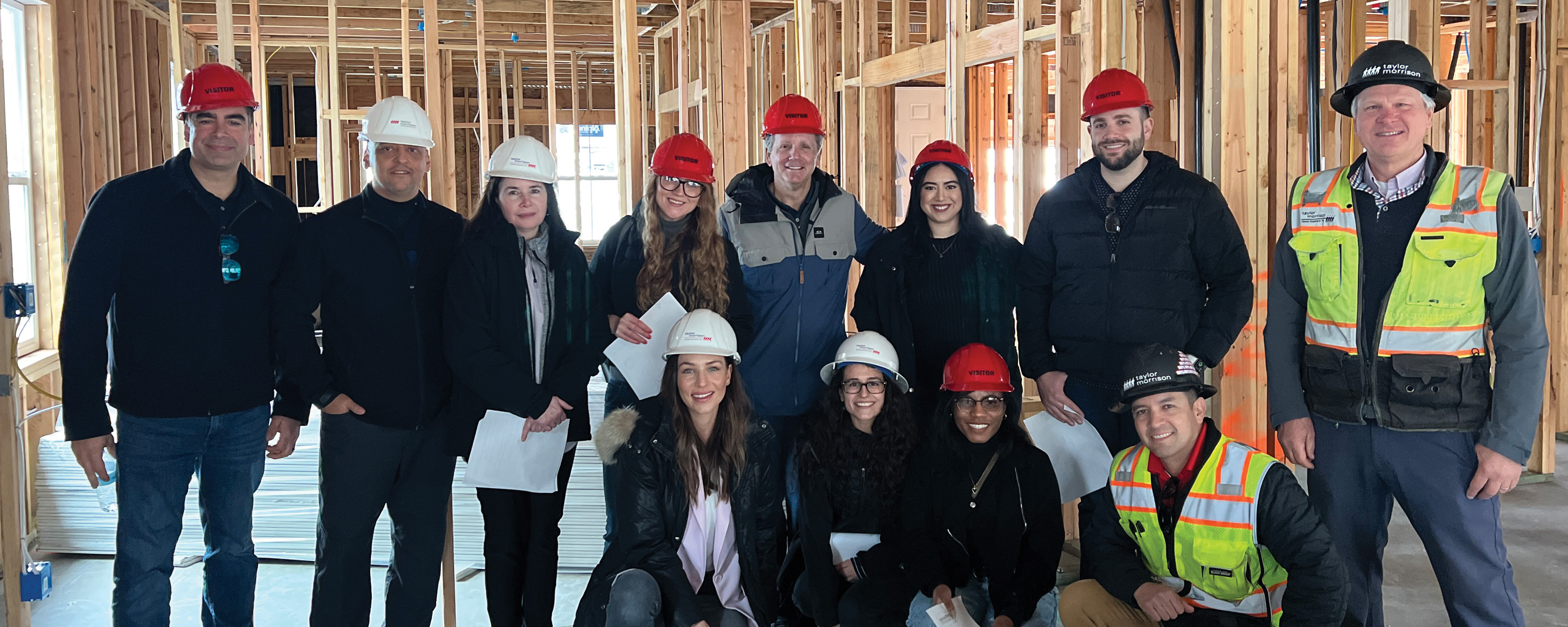 team member in hard hats inside a building under construction