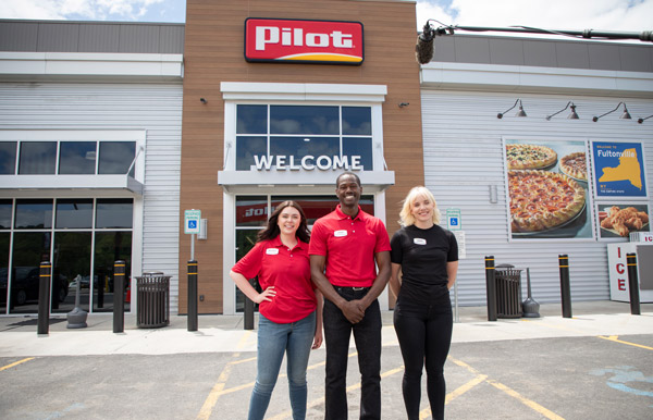 three employees standing in front of a Pilot FlyingJ storefront