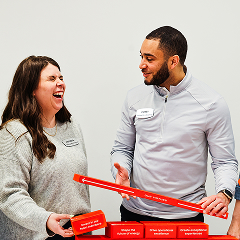 A man and woman wearing name tags laugh and interact during a professional workshop