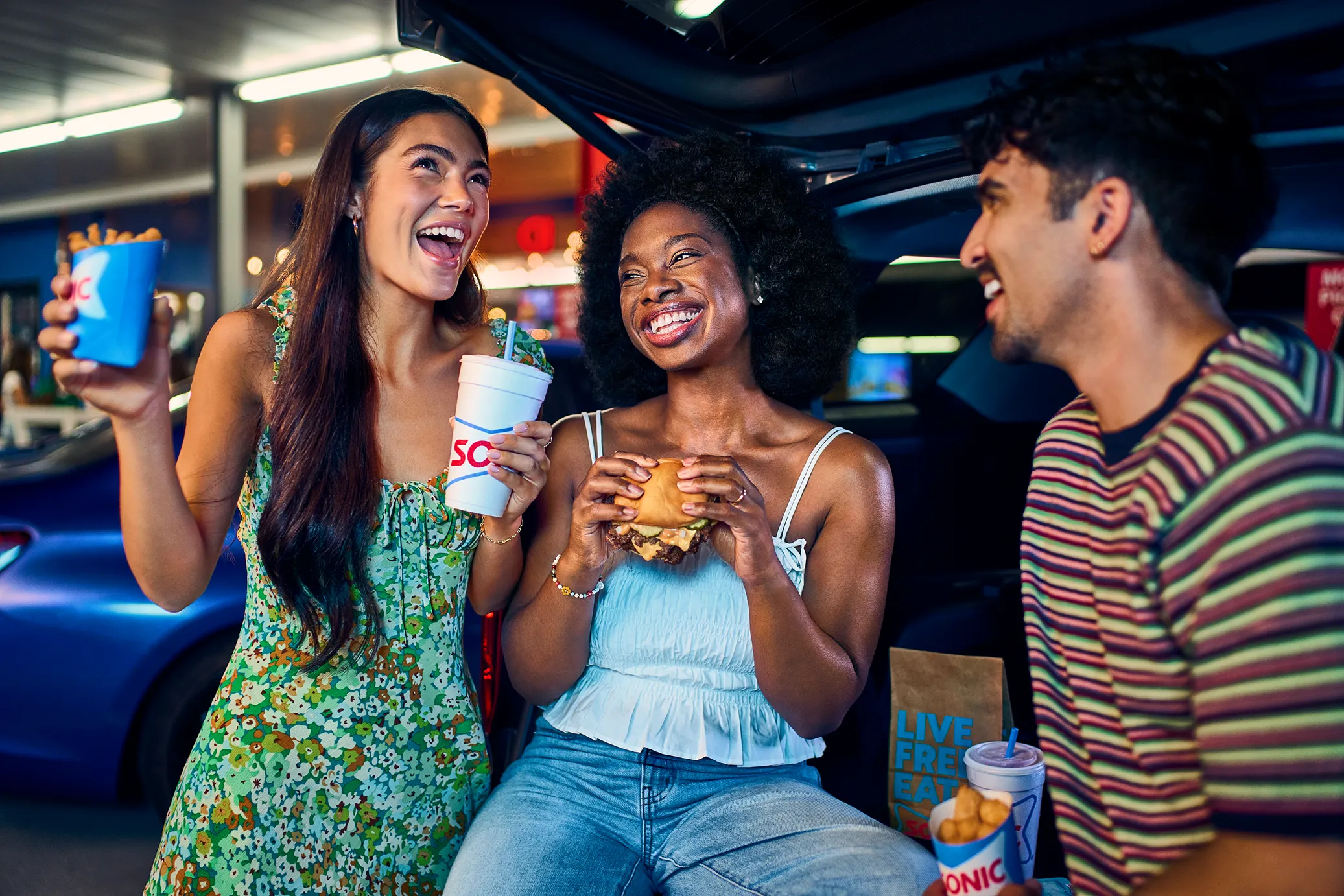 Sonic carhop on roller skates carrying food and drinks in the parking area.