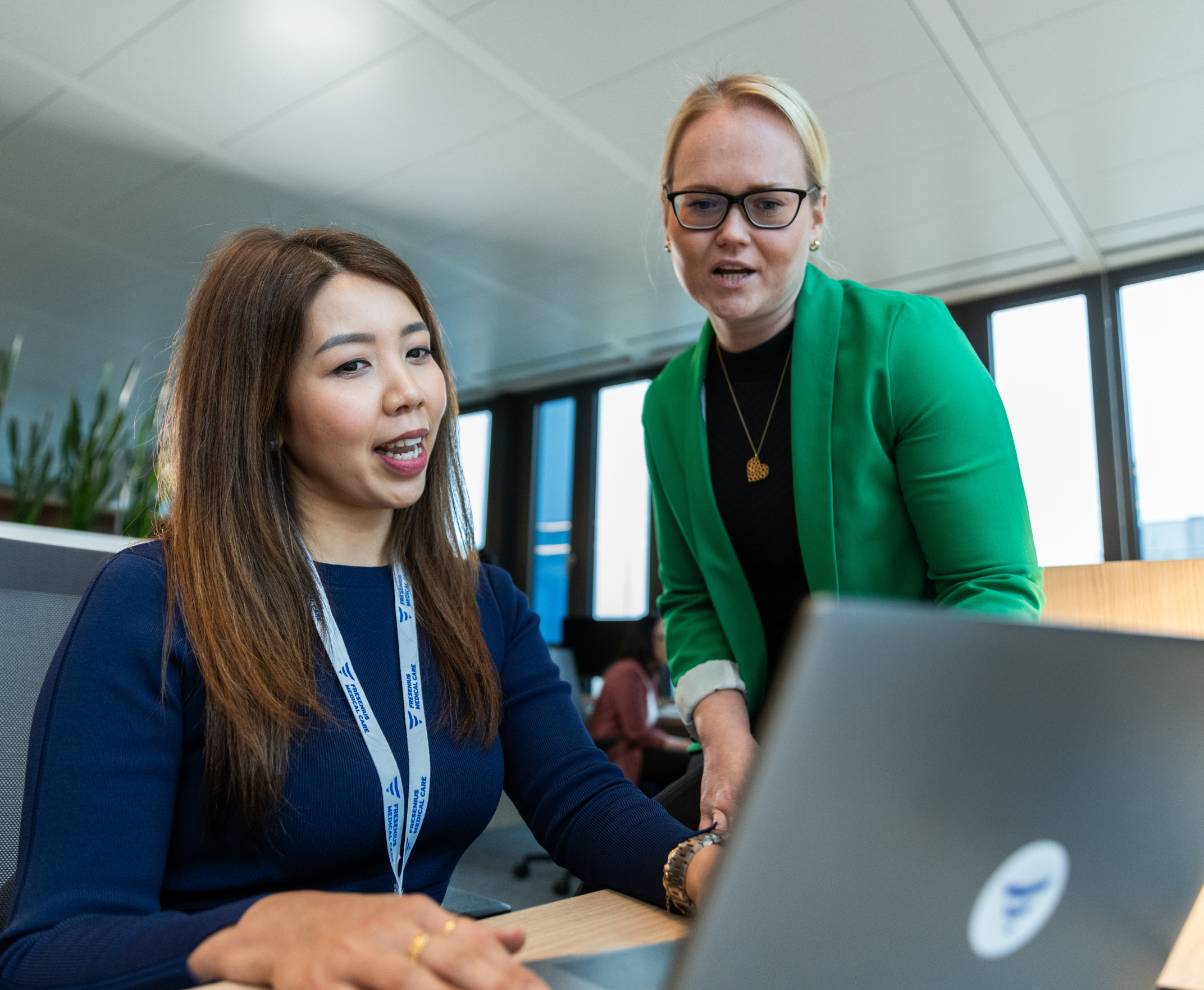 Two female employees reviewing laptop