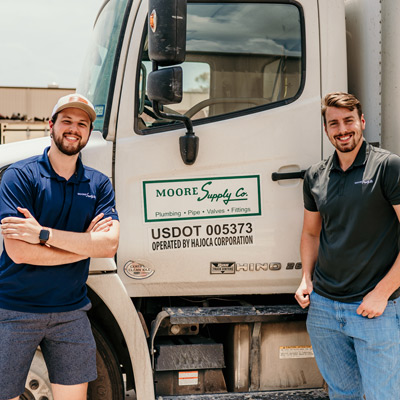 two men standing next to a truck