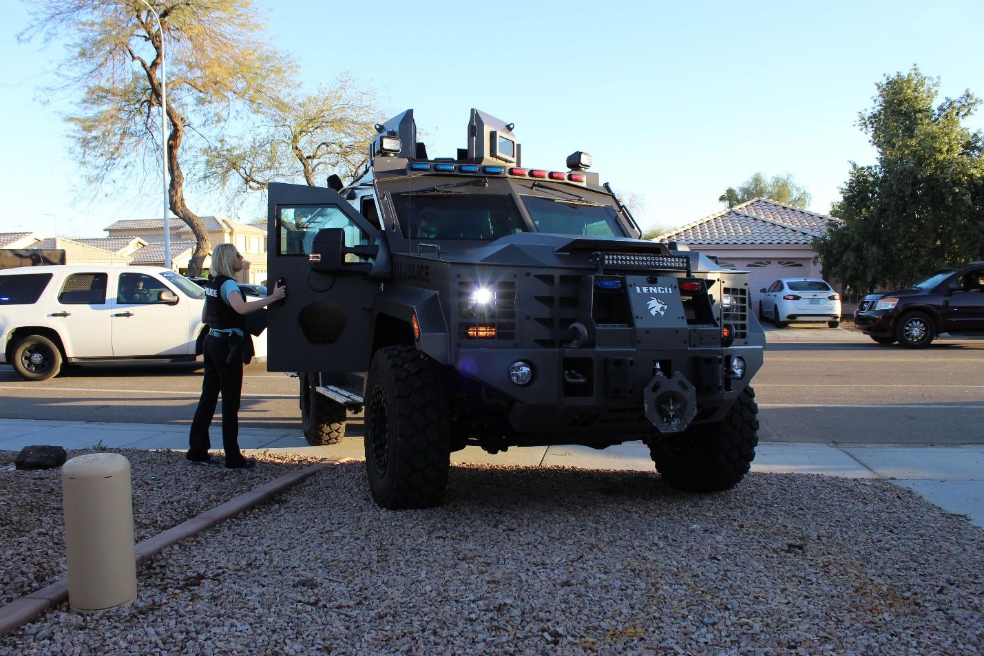 A female police officer standing next to a Chandler Police patrol vehicle