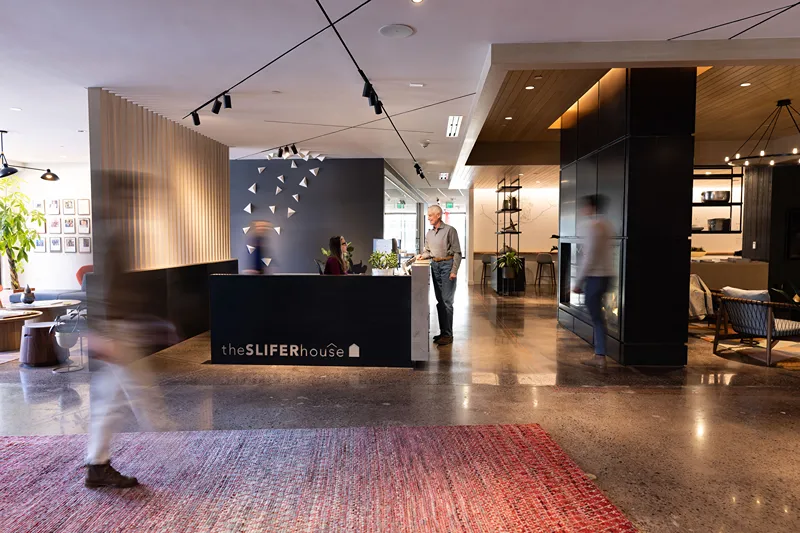 Modern office interior with reception desk and people walking around