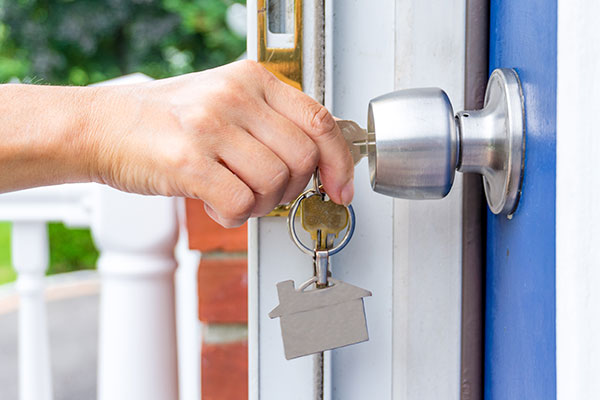 picture of a hand with keys unlocking a door