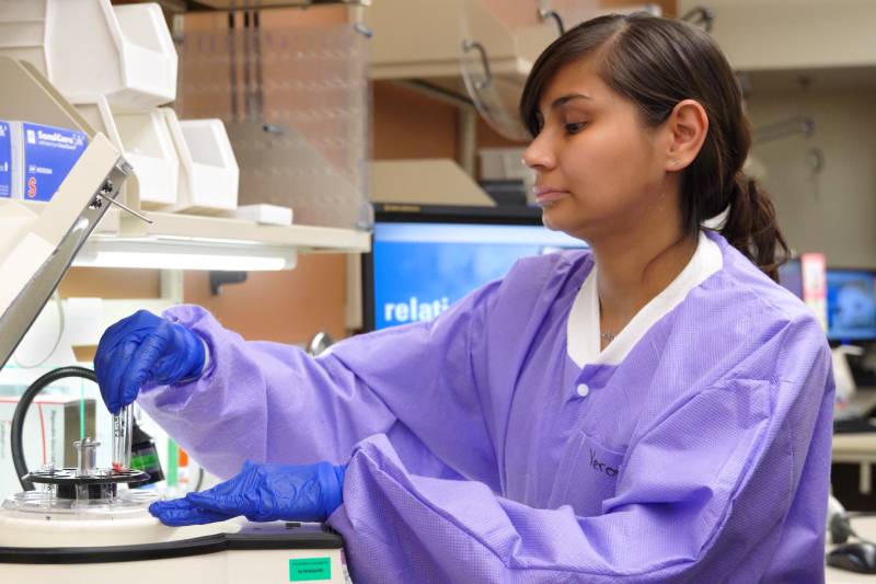 A technician in a labratory examining a vial of liquid