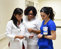 three health care professionals reading a note