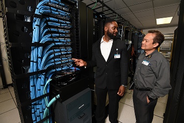 a man talking to another and pointing at wiring