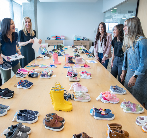 Ladies standing around a table with sample shoes