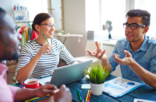 group of three discussing work in office