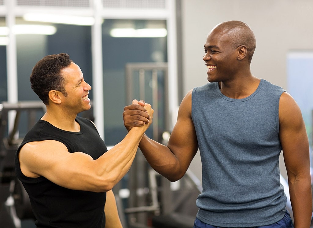 2 men shaking hands in the gym