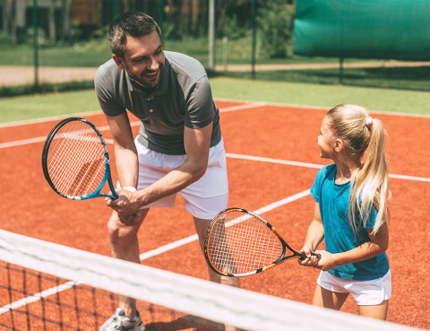 man and a child playing tennis