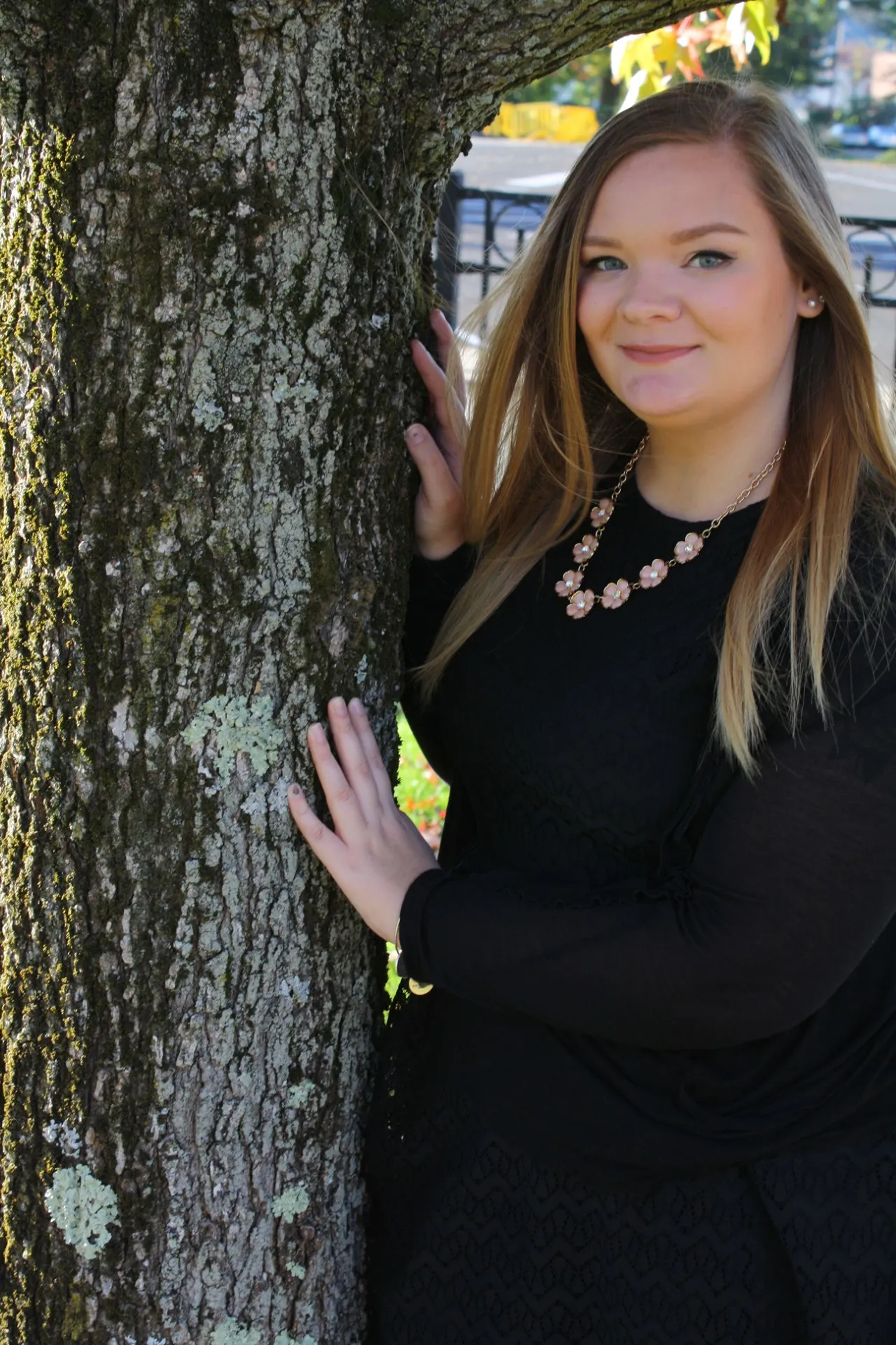 A female doctor in a white coat sits at a computer, smiling.