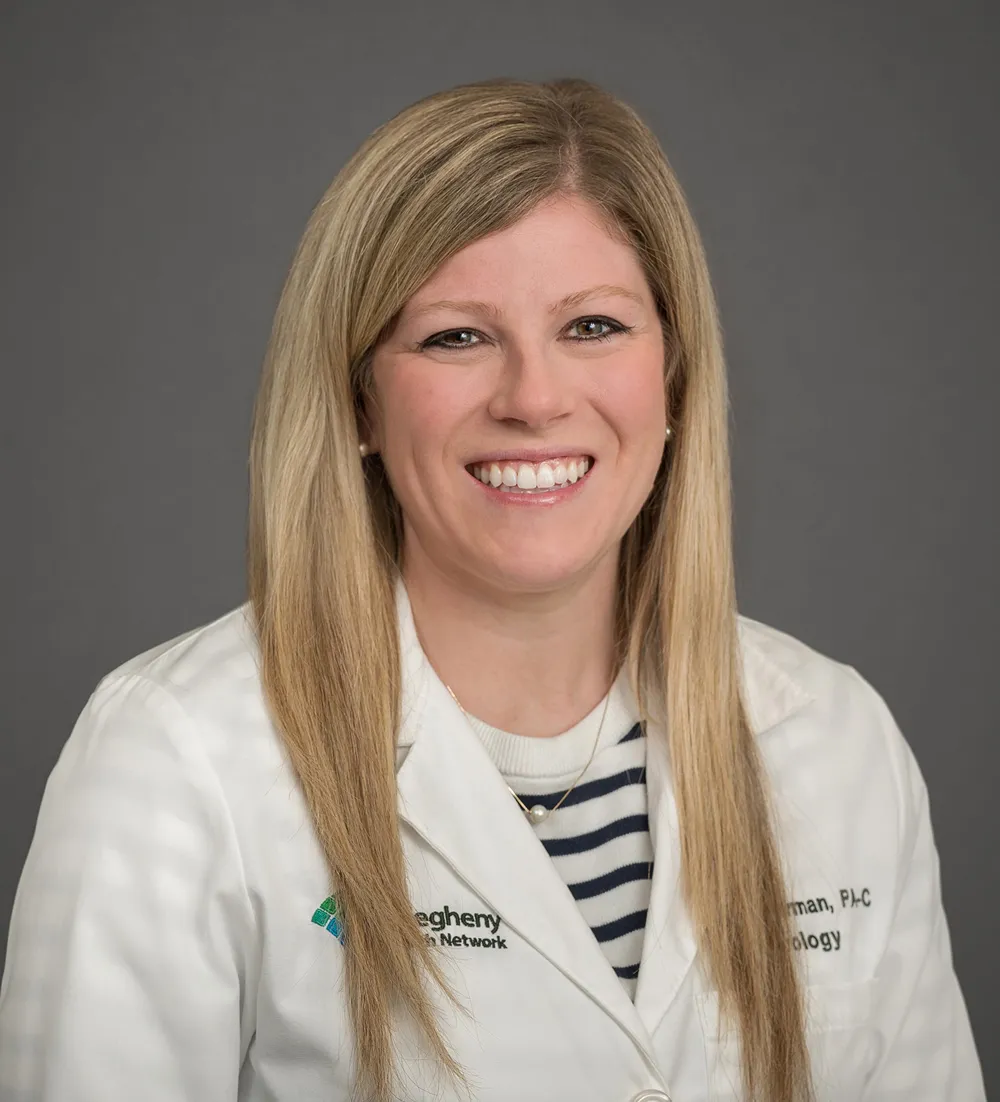 Headshot of a smiling woman with blonde hair wearing a white lab coat