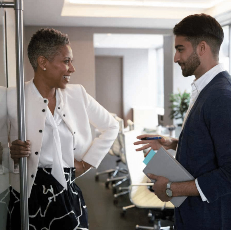 Two people are chatting inside an office